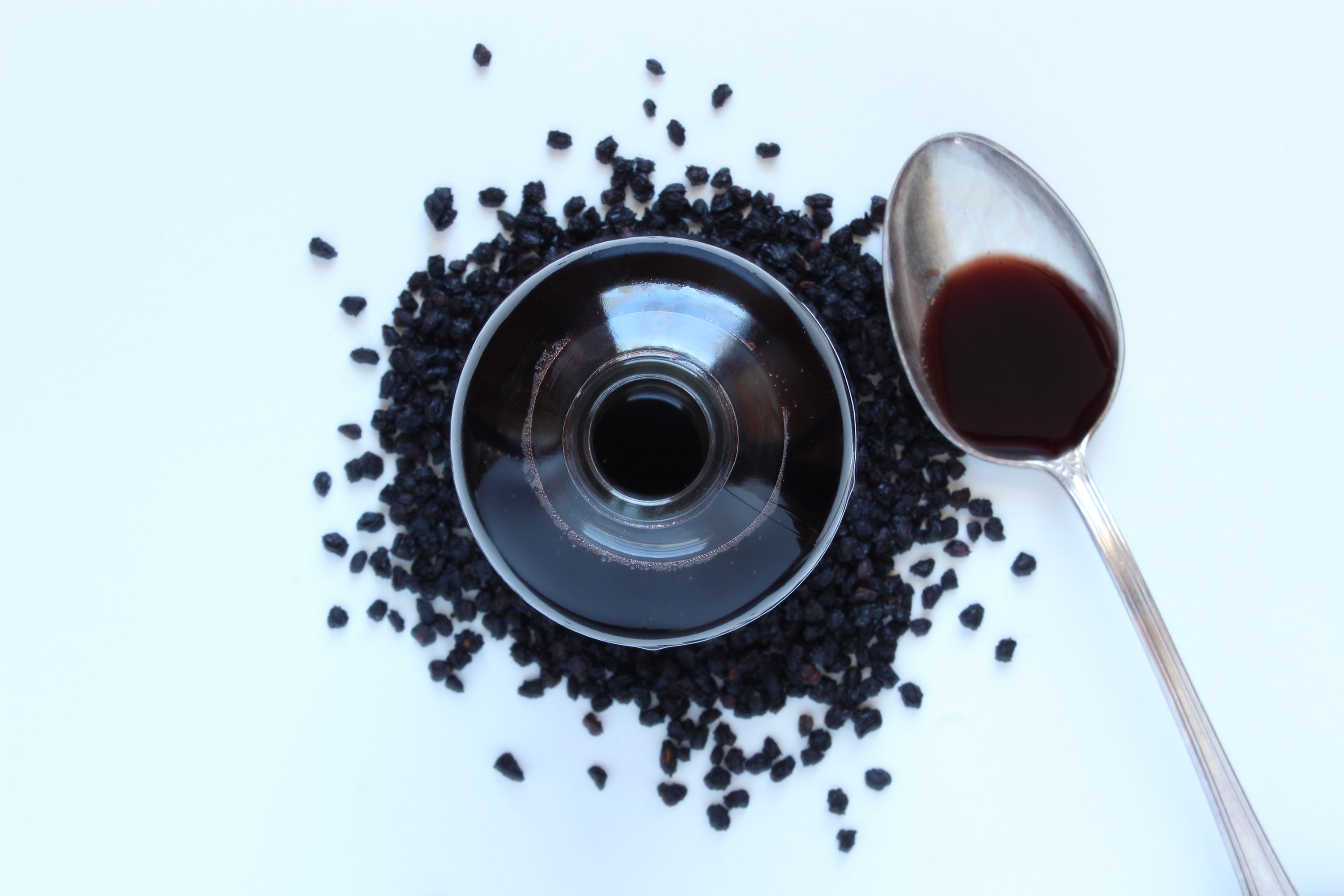 Spoon of Elderberry Syrup with Glass and Elderberries